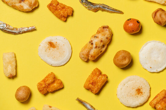 various japanese traditional snacks with crackers,dried fish and yellow background.