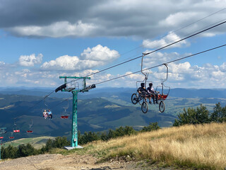 Fototapeta na wymiar Cyclists on a cable car. Funicular to the top of Carpathians Gimba Mountain