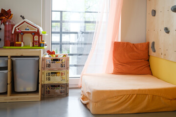 Kids play room, nobody. Nice sunny bright interior at home. Play and rest and create, store things and climb on the wall