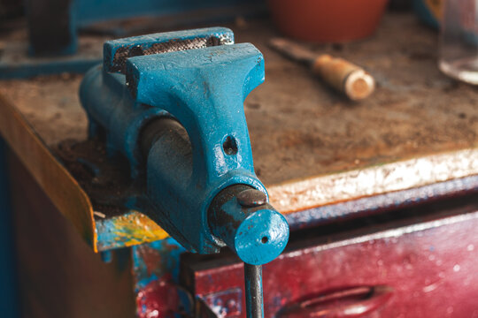 Old vise on workbench,sawn, drilled, milled, filed or marked.