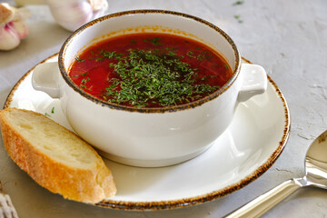 Beetroot soup with herbs and garlic on a light background.