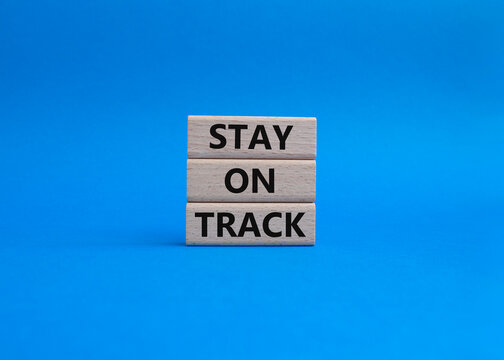 Stay on track symbol. Wooden blocks with words 'Stay on track'. Beautiful blue background. Business and 'Stay on track' concept. Copy space.