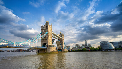 the open tower bridge of london against a dramatic sky