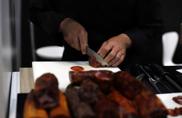 chef cortando lonchas de embutido ibérico con cuchillo