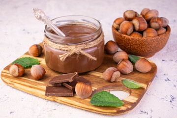 Chocolate spread with hazelnuts on a bamboo board.