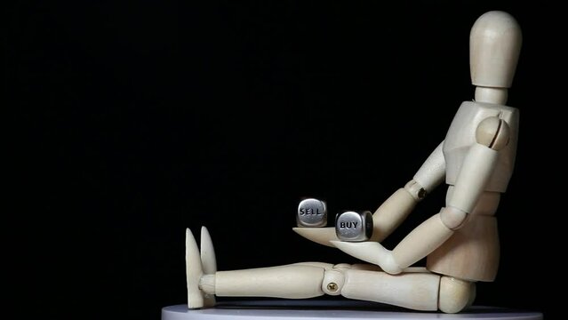 footage of wooden mannequin sell buy cube dark background