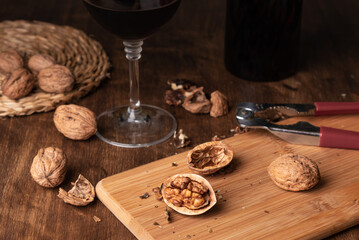 Fototapeta na wymiar Walnuts with a nutcracker and next to a glass of wine and a bottle. Close-up.