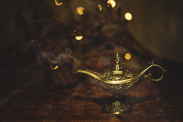 Ornamental ramadan aladdin's lamp with smoke and bokeh background still life photography