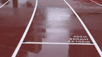 Rainy day, Athletics track in the stadium. The ground marks The ground marks 400m, 400mH, 4*100m.