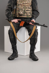 A soldier sits in a protective mask and uniform