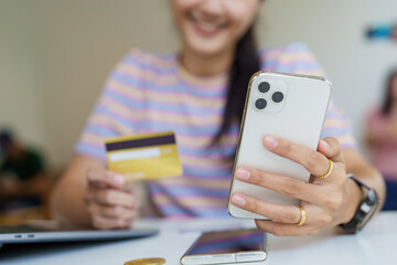 Online Shopping and Internet Payments, Portrait of Beautiful Asian women are using their credit cards and mobile phones to shop online or conduct errands in the digital world