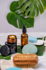 Nachhaltige Kosmetik mit Braunglasflasche, Seife, Creme, Tiegel, Abschminkpads, Büste, Schwamm und Q-tips aus Bambus Flatlay Gesichtspflege, exotisch inszeniert