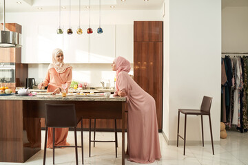 Muslim women spending leisure time together in kitchen