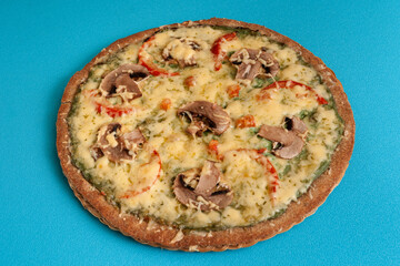Pizza with mushrooms,cheese and tomatoes on a blue background.