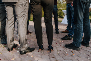 Legs of stylishly dressed people, men, women close-up outdoors. Business, meeting and meeting of businessmen about work. Holiday, corporate party of friends.