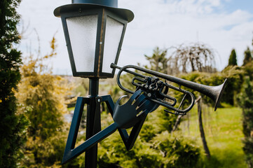 An ancient bronze, metal lantern sculpture of a trumpeter - a musician stands in a city park....