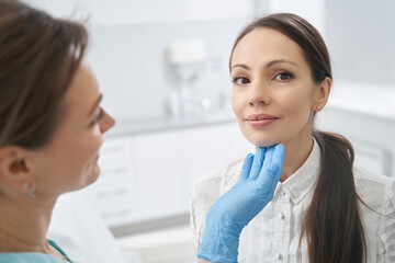 Woman having facial skin examination in beauty salon