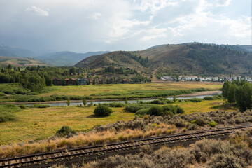 Beautiful Colorado landscape with river and mountains and railroad tracks in the foreground