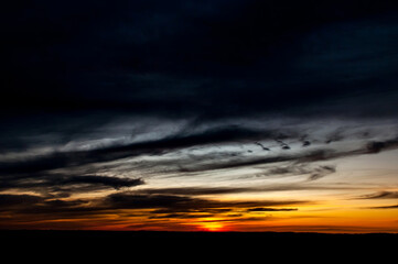 Dusk, early evening, orange sunset on the field.