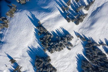 Drone photography of snowboarding and ski tracks left in the snow high in mountains.
