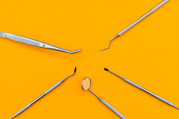 Dental mirror and other tools on orange background