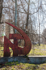 Rusted symbols of the Soviet Union. Hammer and sickle. Old, destroyed symbols of the Soviet Union in an abandoned city.