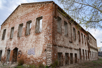 Old red brick building 2 floors destroyed by time and weather. - obrazy, fototapety, plakaty