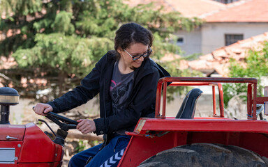Selective focus shot of woman backing with tractor checking her back.