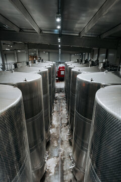 Huge warehouse for wine storing with giant stainless steel tanks. Industrial production of alcohol drink theme.