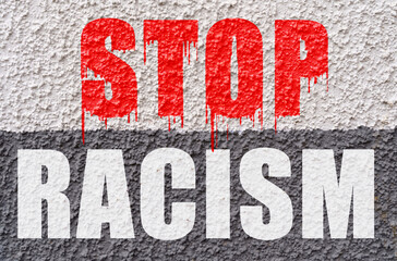On the white-gray surface of the wall is the inscription - Stop Racism