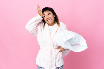 Young Uruguayan woman in pajamas over isolated pink background having doubts with confuse face...