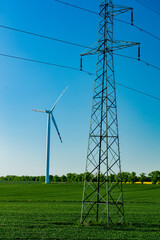 wind farm and high-voltage line in a green wheat field