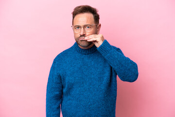 Middle age caucasian man isolated on pink background showing a sign of silence gesture