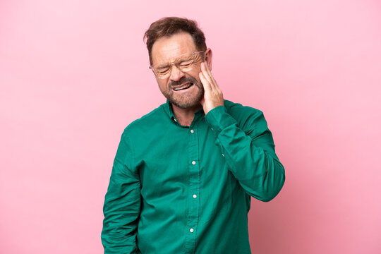 Middle age caucasian man isolated on pink background with toothache
