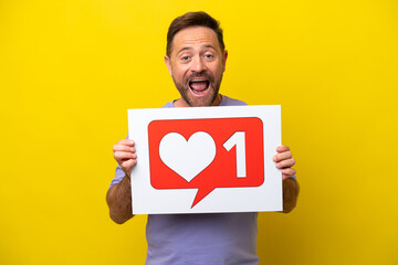 Middle age caucasian man isolated on yellow background holding a placard with Like icon with happy expression