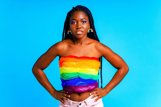 young woman wearing colorful blouse standing isolated over blue background, lgbt concept