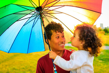multicultural race family covering from the sun under the bright umbrella © yurakrasil
