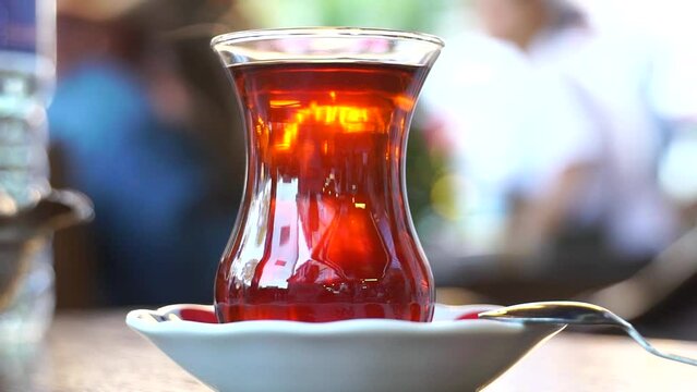 Close up view of young teen girl drinking tea in a cafe. Slow motion.It fills Turkish tea into a glass special to the Turks.