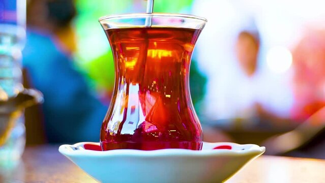 Close up view of young teen girl drinking tea in a cafe. Slow motion.It fills Turkish tea into a glass special to the Turks.