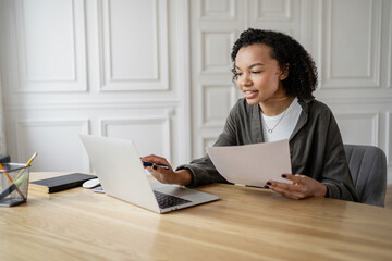 A female financier uses a laptop to work in an office. Coworking space company finance report.