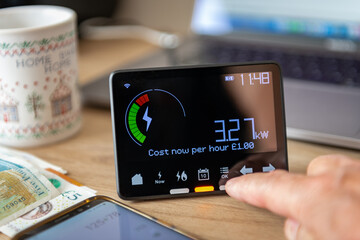 A person checking and calculating rising home energy cost with smart meter. Inflation, cost of...