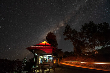 Milky way over small stall that selling traditional indonesian food, coffee and instant noodles, a...