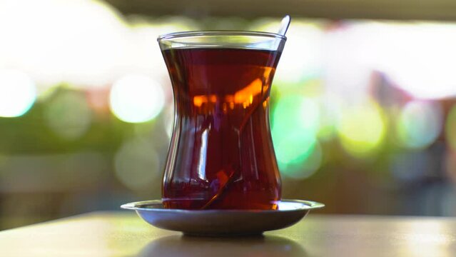 Close up view of young teen girl drinking tea in a cafe. Slow motion.It fills Turkish tea into a glass special to the Turks.