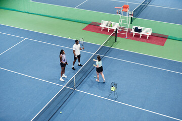 High angle shot of African American couple playing tennis at practice with partner or coach, copy...