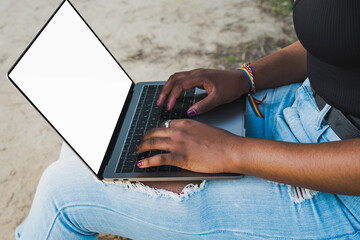 Naklejka premium Close-up of African American woman's hands using laptop computer, sitting on park bench. Mockup.