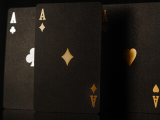 Black poker cards on a dark background. Three aces are a symbol of winning, wealth, success. Macro shot. Casino, nightclub, online casino, gambling, poker game, win, risk. Advertising, banner.