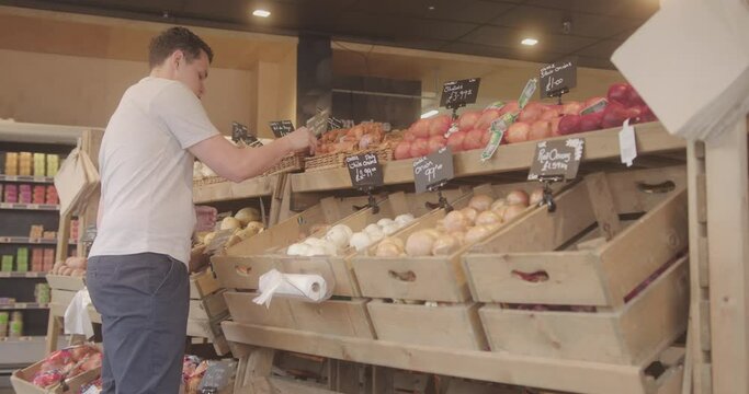 Supermarket Employee Stacking Shelfs with Fresh produce