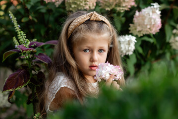 little girl with pink flower of hydrangea