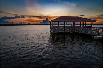 A gazebo with people watching a sunset over the river in Florida