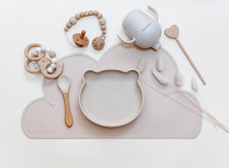 Silicone dishware on light background. Serving baby, first feeding concept. Kids tableware. Flat lay, copy space, top view - obrazy, fototapety, plakaty